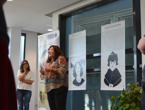 Núria Salán davant del panell de la Teresa Puig amb públic a la visita guiada a l'Enciclopèdia de Dones STEAM a l'IMB-CNM
